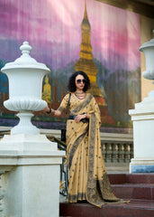 Woman in a beige saree standing on steps with a colorful mural in the background
