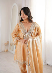 Woman wearing a gold sequin outfit in a bright room
