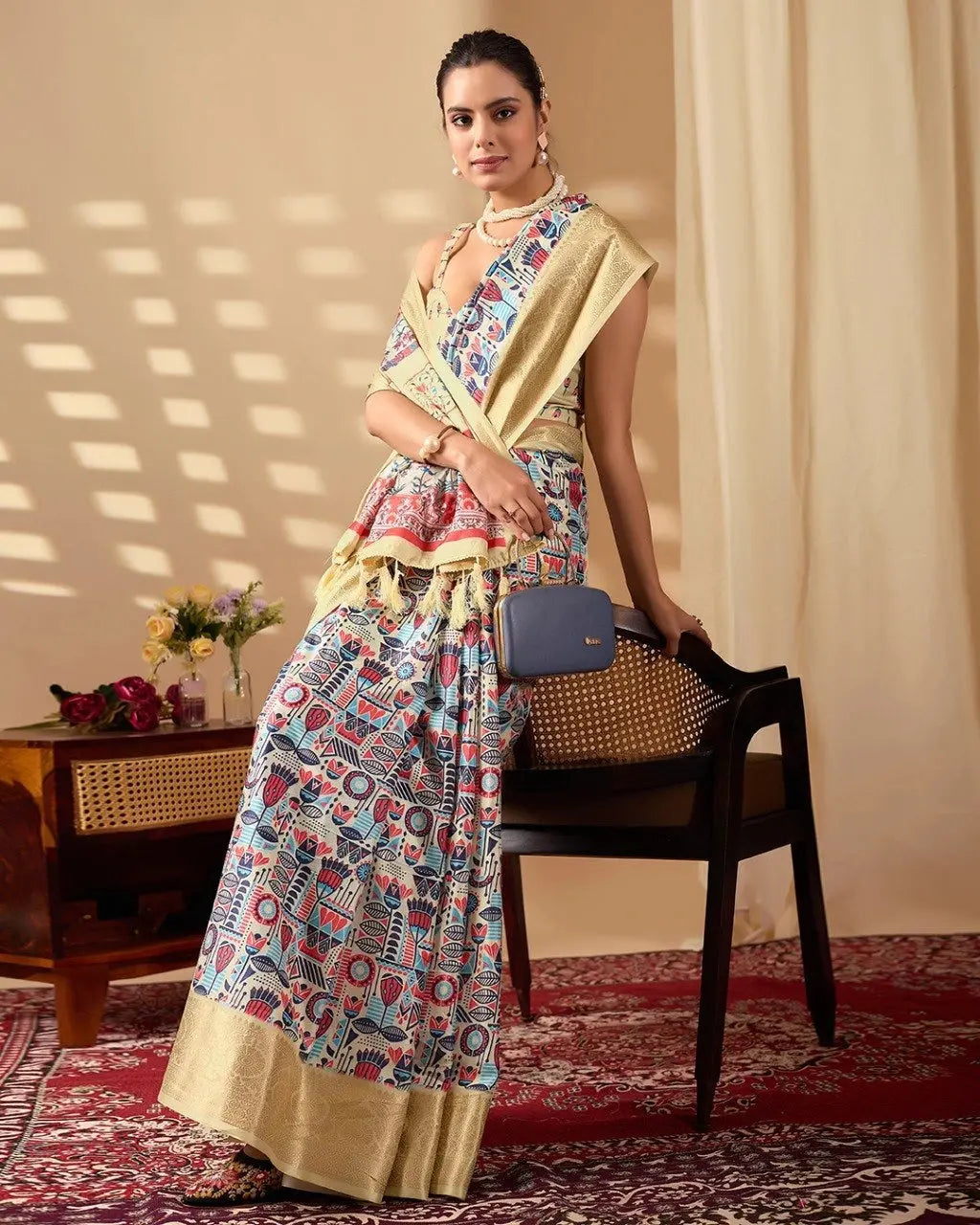 Stylish woman posing in a designer printed saree with a golden zari border, creating a sophisticated festive and ethnic look.