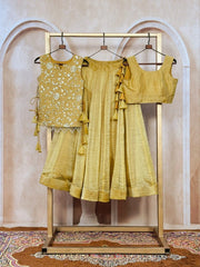 Yellow traditional outfit on a wooden rack against a beige wall.