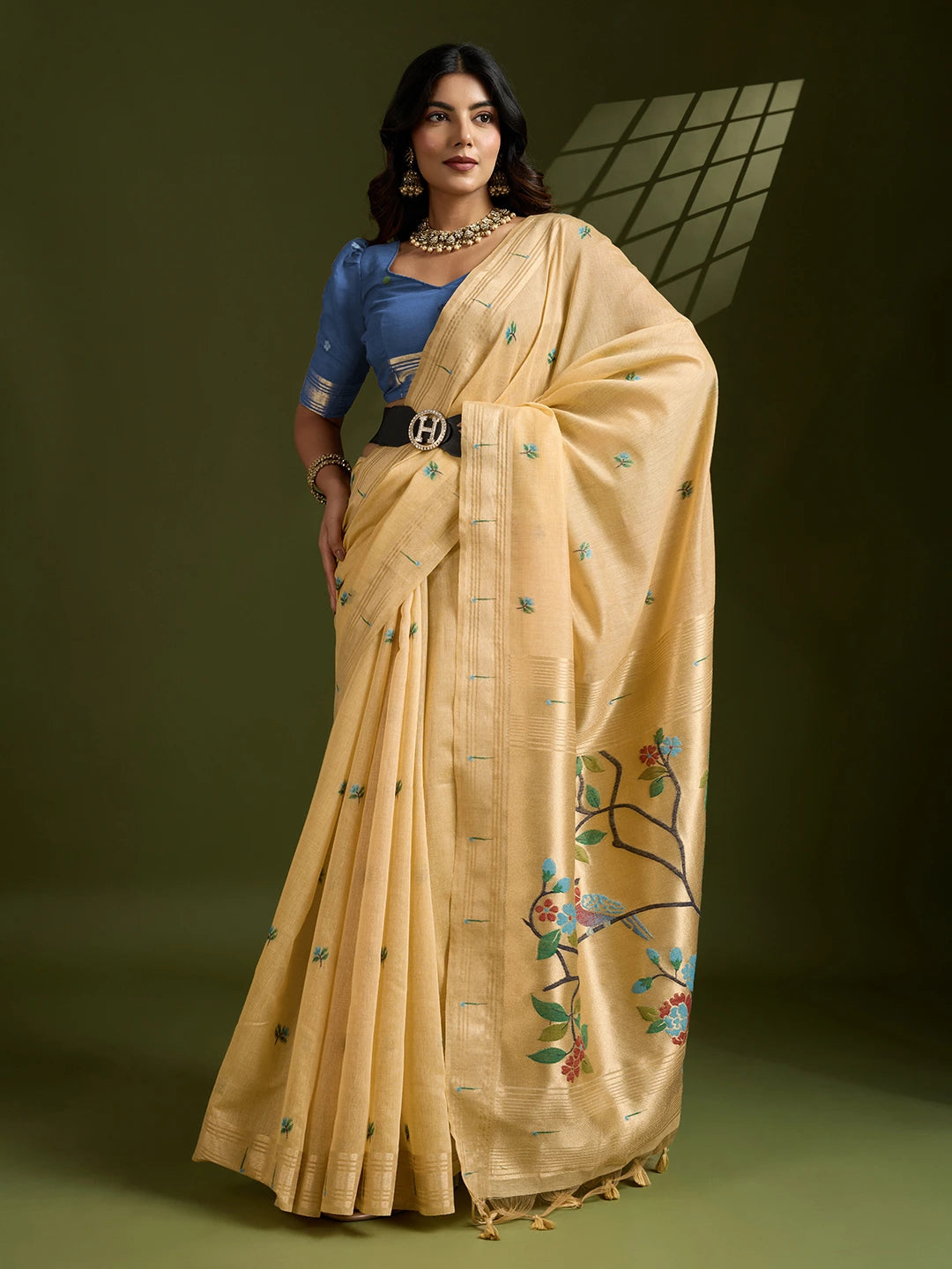 Woman wearing a purple and pink saree with floral patterns in a room setting.