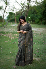 Woman in black traditional weaving saree showcasing elegant style in a garden setting