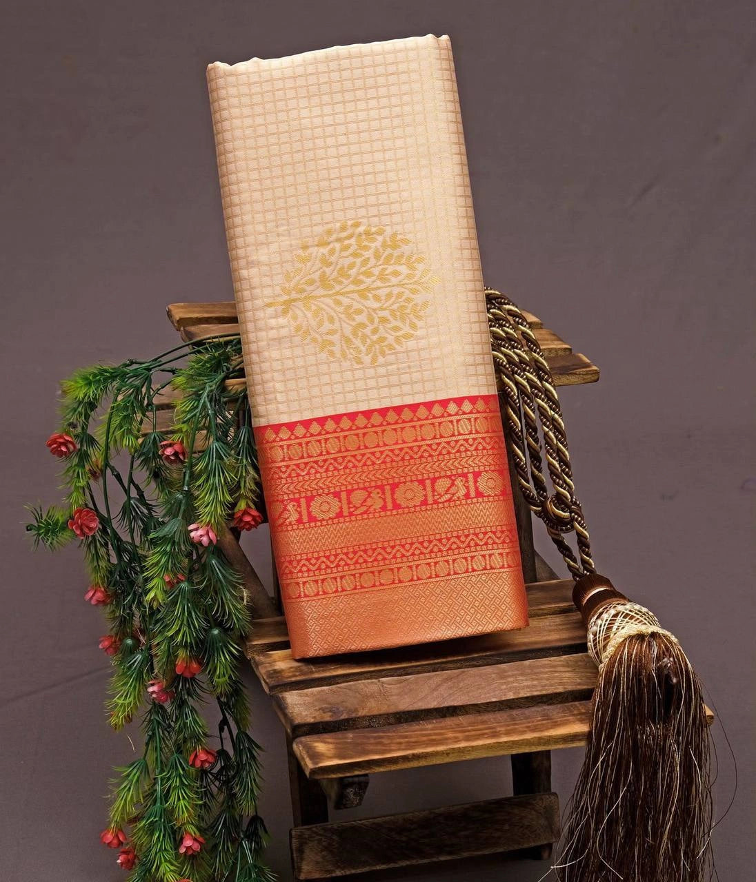 Cream jacquard weaving saree folded on wooden stool showing red zari border – Kalyanja KS409