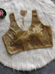Gold sequin sleeveless blouse with tie-back detail, displayed on a white fur background with a pink floral prop