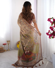 Woman wearing a patterned saree in a bright room with flowers and decor items.