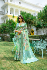 Woman wearing light green pastel saree with zari work and floral design in a luxurious garden setting