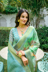 Woman wearing light green pastel saree with zari work and floral design