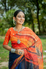 Deep navy blue organza saree with vibrant orange geometric digital print pattern embroidered blouse silver tribal pendant necklace jasmine flower earrings outdoor portrait ethnic contemporary fashion