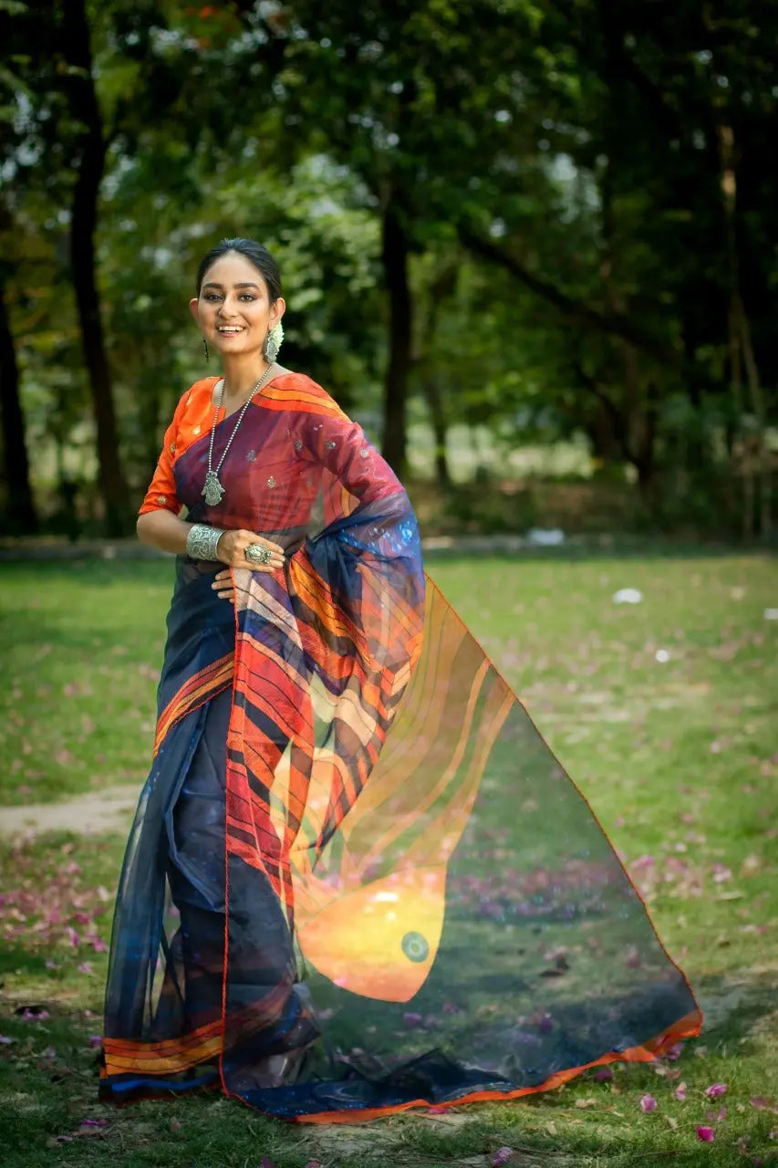 Deep navy blue organza saree with vibrant fish pattern print and orange border styled with matching blouse silver tribal jewelry