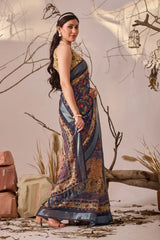 Woman in a patterned dress standing against a rustic background with branches and stones.