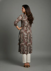 Woman wearing a patterned kurta with white pants against a gray background