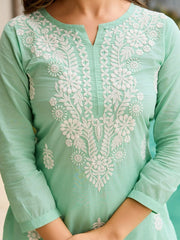 Mint green kurta with white floral embroidery on a blurred background