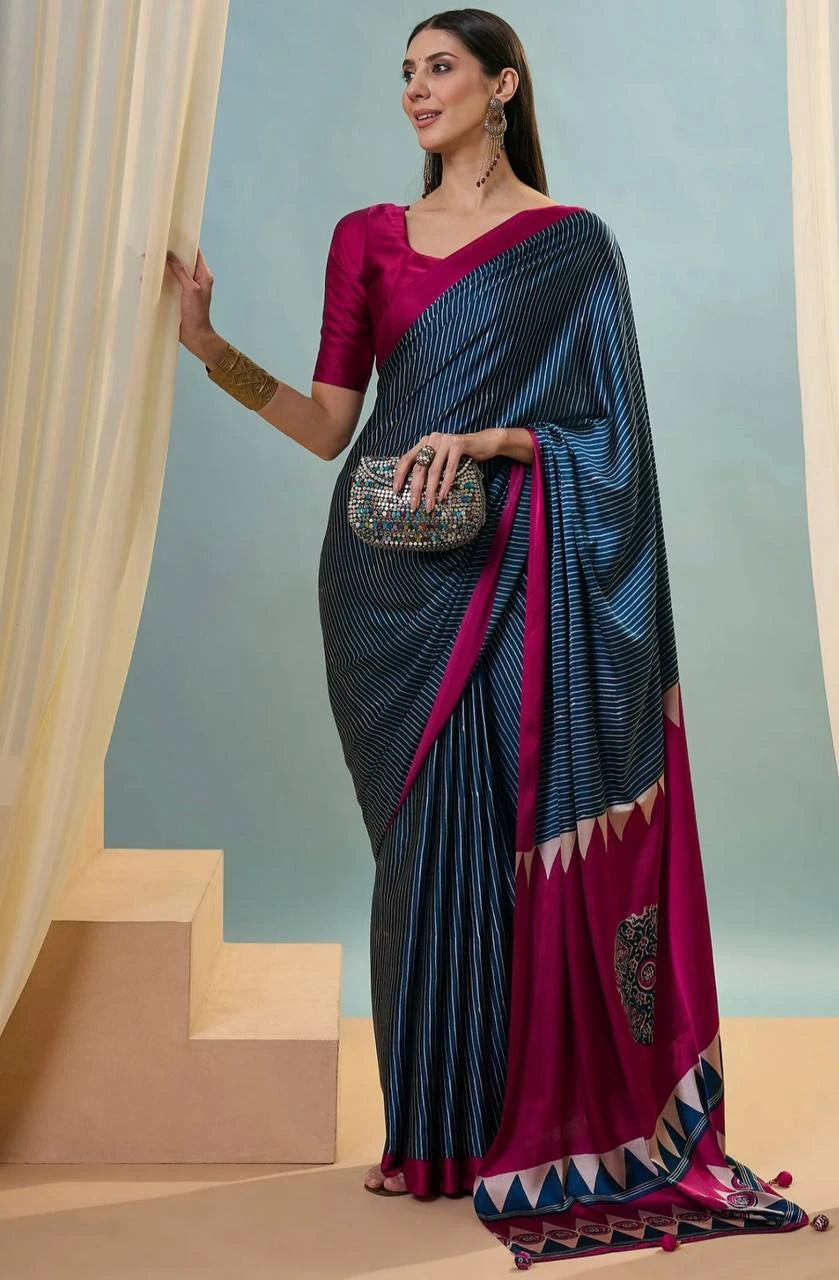 Woman wearing a black and pink saree with a clutch against a light blue background