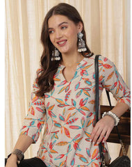 Woman wearing a colorful patterned top with a neutral background
