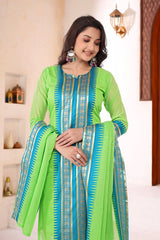 Woman wearing a green and blue traditional outfit with intricate patterns.