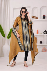 Woman wearing a mustard yellow kurta with black and white patterns in a minimalistic room.