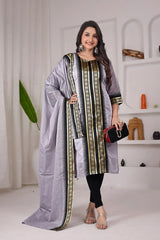 Woman wearing a traditional outfit with a long scarf in a minimalistic setting