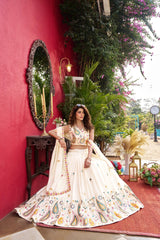 Woman in a traditional outfit standing against a red wall with decorative elements.