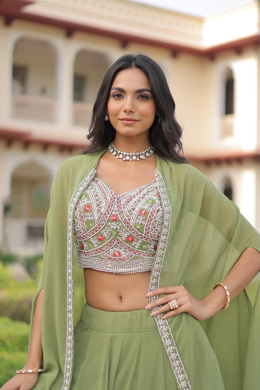 Woman in a green traditional outfit with embroidery, standing outdoors.