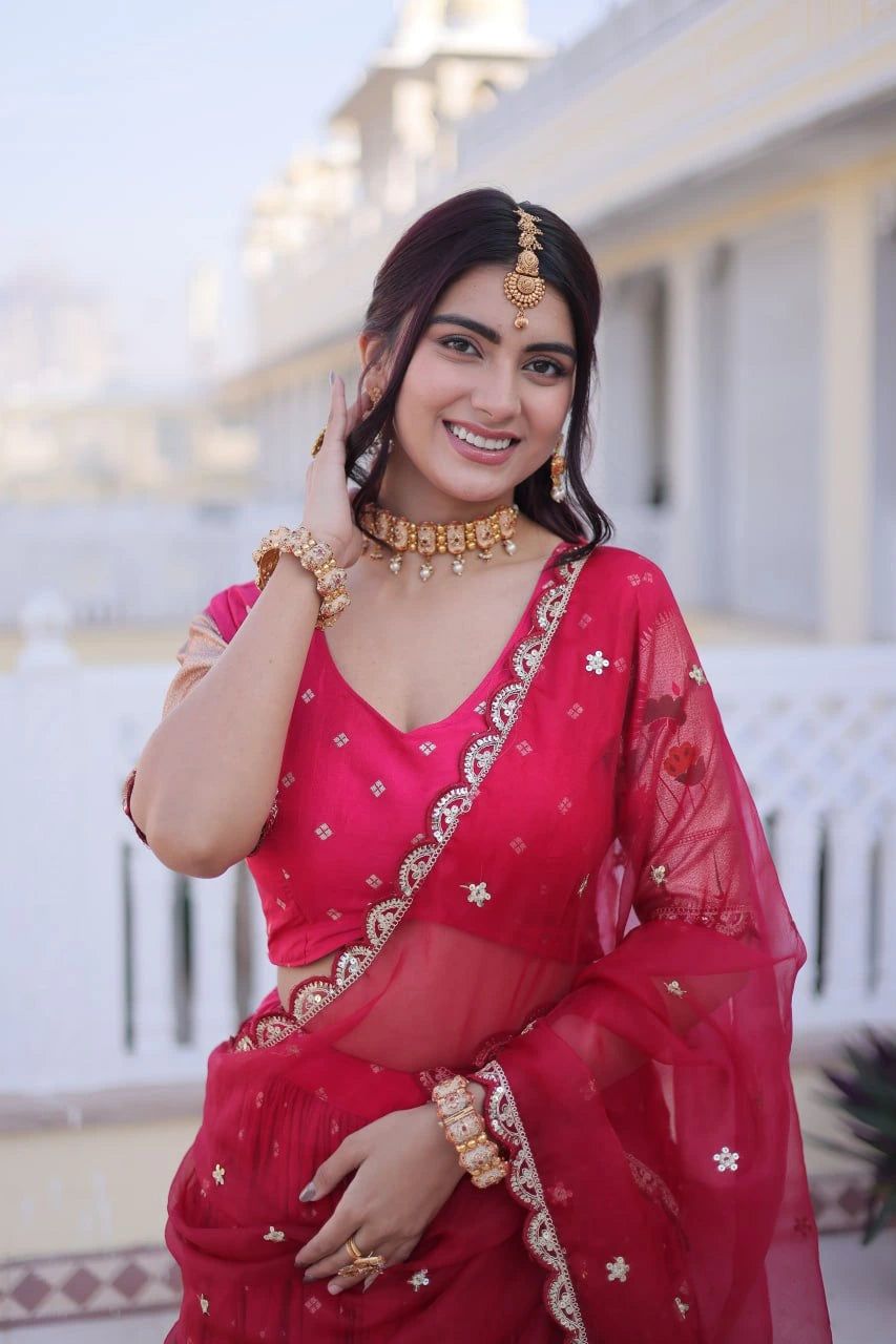 Woman in a red saree with gold jewelry outdoors
