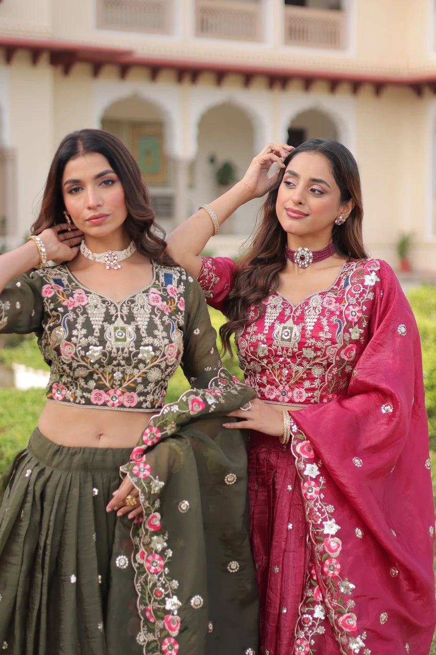 Two women in traditional outfits standing outdoors with a building in the background