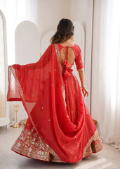 Woman in a red traditional outfit with gold embroidery standing in a bright room.
