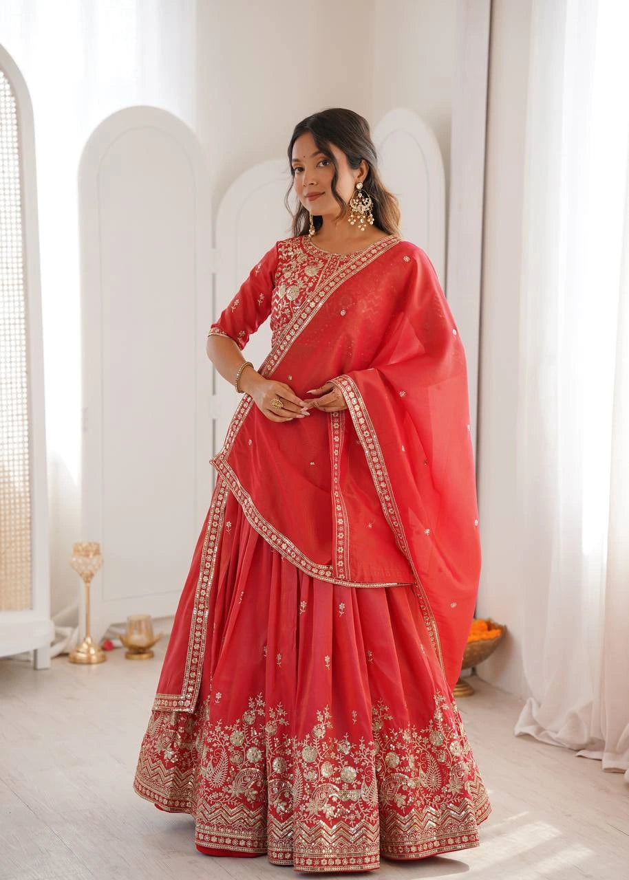 Woman wearing a red traditional outfit with gold embroidery in a bright room.