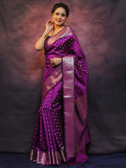 Woman wearing a purple saree with a dark background