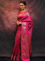 Woman wearing a pink saree with a dark background