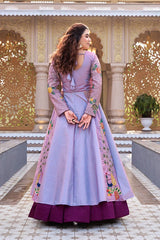 Woman in a traditional outfit with floral embroidery standing in front of an ornate architectural background.