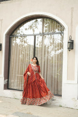 Woman in a red traditional outfit standing in front of a glass door.
