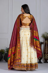 Woman wearing a traditional outfit with a maroon dupatta in an indoor setting