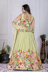 Woman wearing a light green floral embroidered dress in a decorated room.