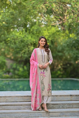 Woman in traditional outfit with pink dupatta standing outdoors