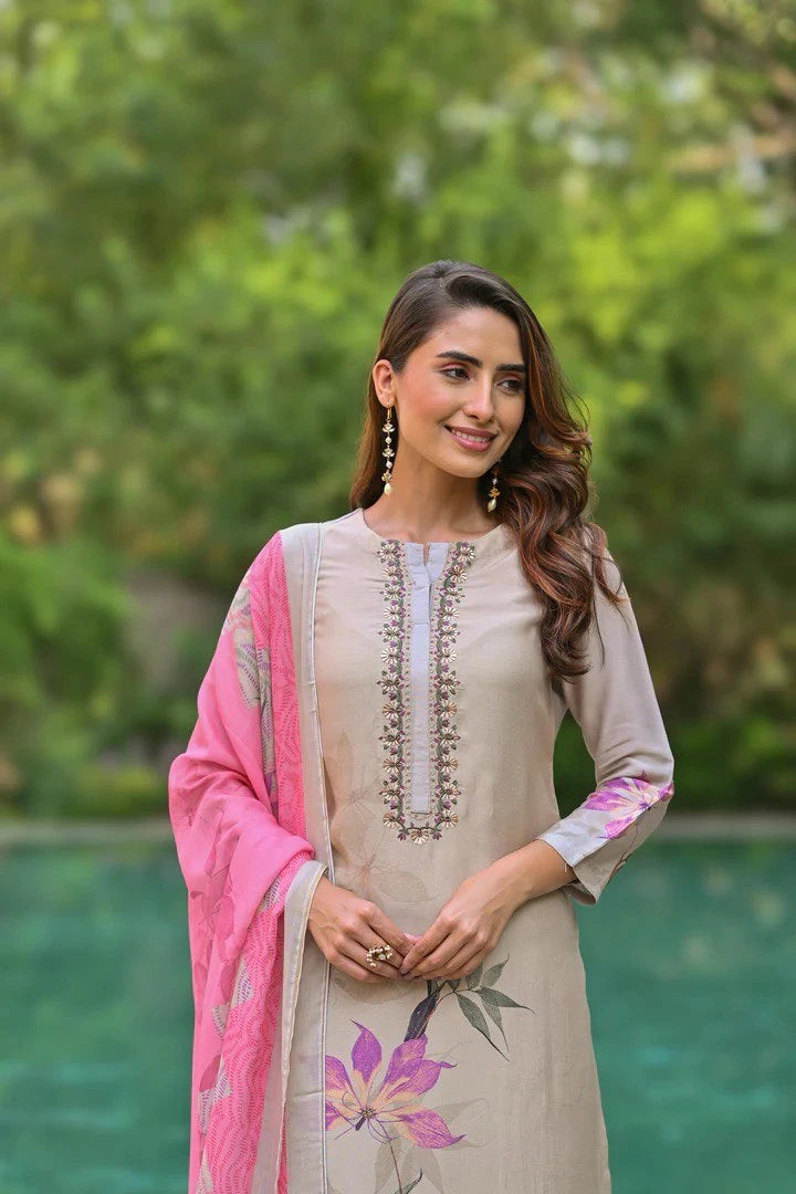Woman wearing a beige embroidered kurta with pink dupatta in a garden setting