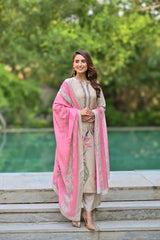 Woman in a traditional outfit with a pink dupatta standing outdoors.