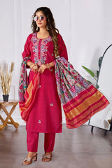 Woman wearing a pink traditional outfit with a colorful dupatta in a room setting.