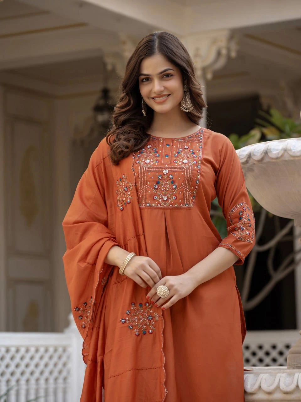 Woman wearing an orange embroidered dress in an outdoor setting
