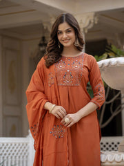 Woman wearing an orange embroidered dress in an outdoor setting