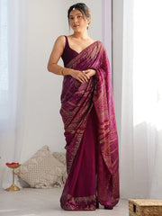 Woman wearing a maroon saree with a white background