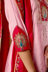 Close-up of a red and pink traditional outfit with intricate embroidery.