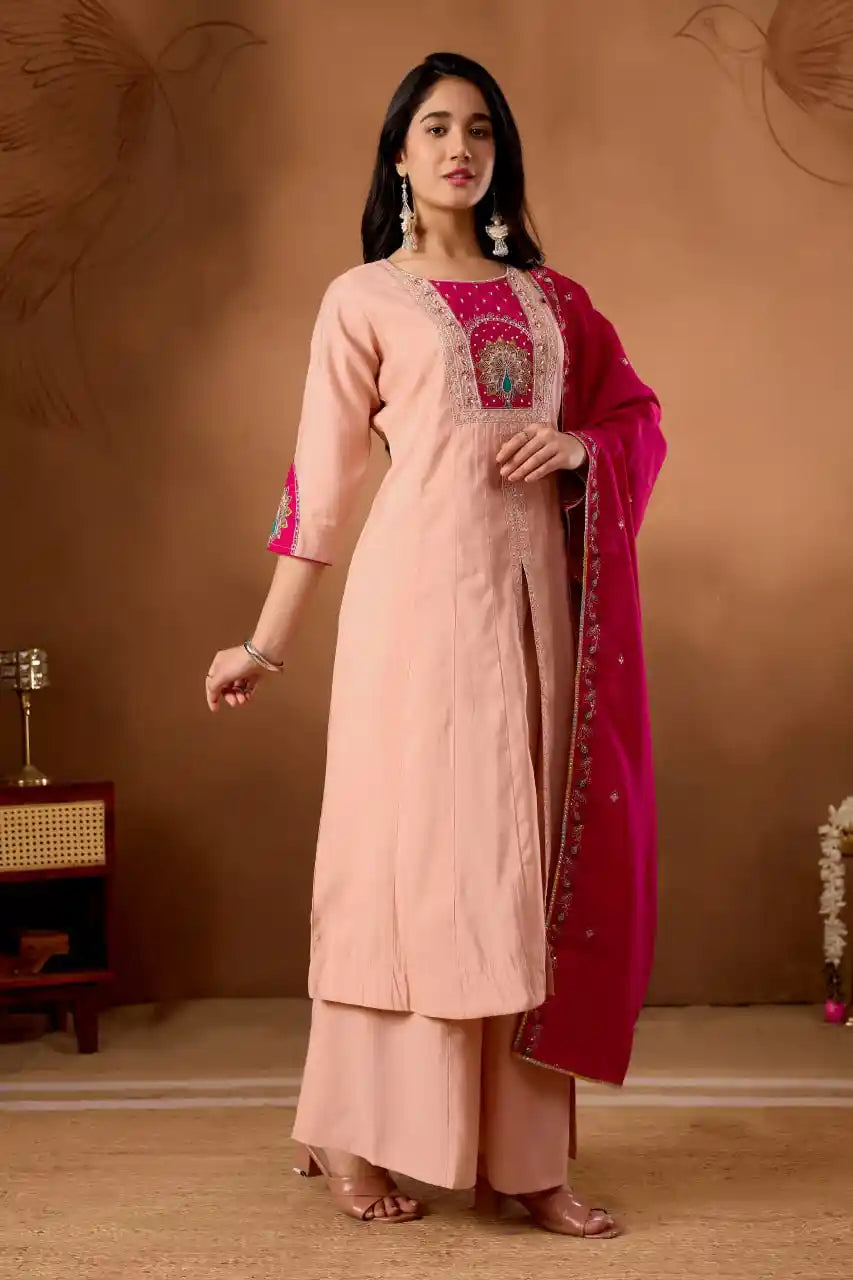 Woman wearing a peach kurta with pink dupatta against a brown background