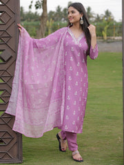 Woman in a purple traditional outfit with a matching dupatta standing outdoors.