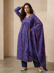 Woman wearing a blue patterned kurta with a matching dupatta against a beige background