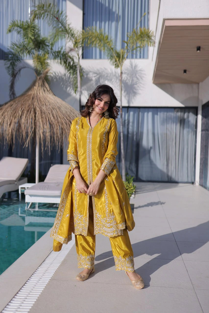 Woman in a yellow traditional outfit standing by a poolside.