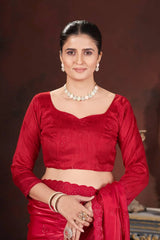 Woman in a red traditional outfit with jewelry against a dark background