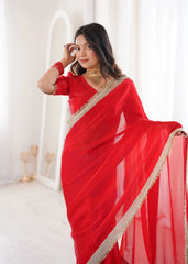 Woman wearing a red saree with gold border against a white background