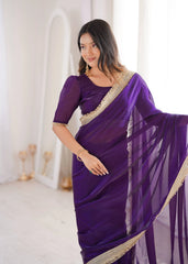 Woman wearing a purple saree with gold border in a white room