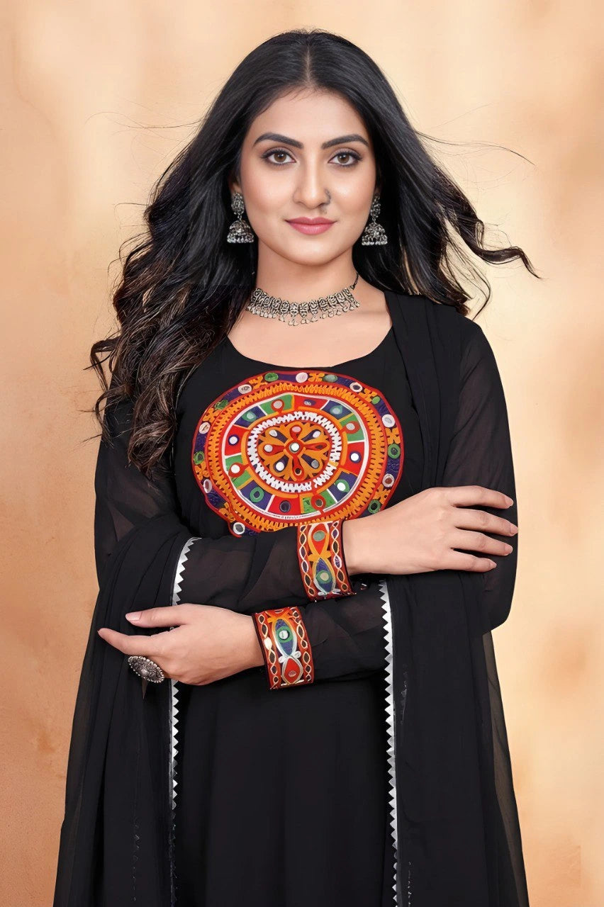 Woman wearing a black outfit with colorful embroidery against a beige background