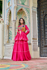Woman in a bright pink traditional outfit standing in front of ornate architecture.
